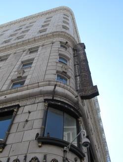 The building s rounded corner and lack of an overhanging cornice marks the style as transitional from Beaux-Arts to Art Deco. R - In 2012 is undergoing $15 million conversion to 88 apartments.