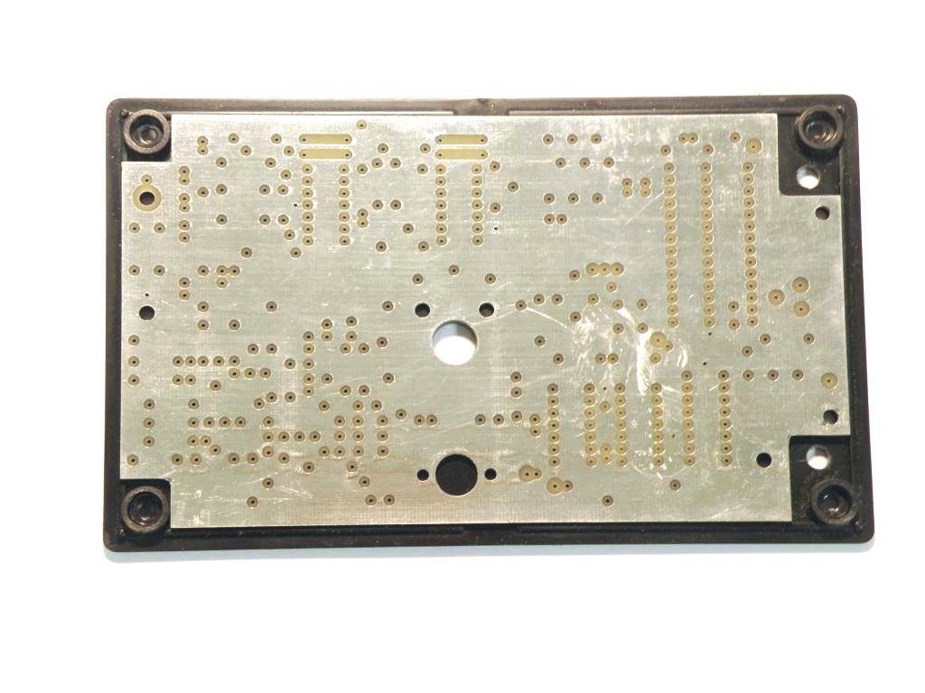 The bare circuit board serves as a template for drilling the frequency rotary switch (center) and the board mounting holes (2 at each end).