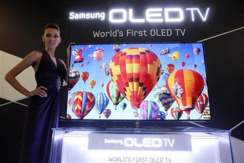 In this May 10, 2012 photo, a model poses with a 55-inch Samsung OLED, organic light-emitting diode, TV during a press conference in Seoul, South Korea.