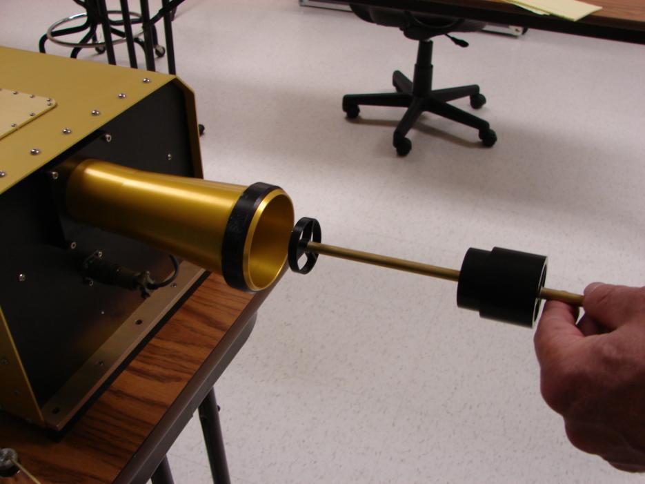 7.) Place the calibration fixture in the instrument. Figure 28 shows a calibration fixture being inserted into an FM-100. Figure 28: Inserting the Calibration Fixture into the Fog Monitor.
