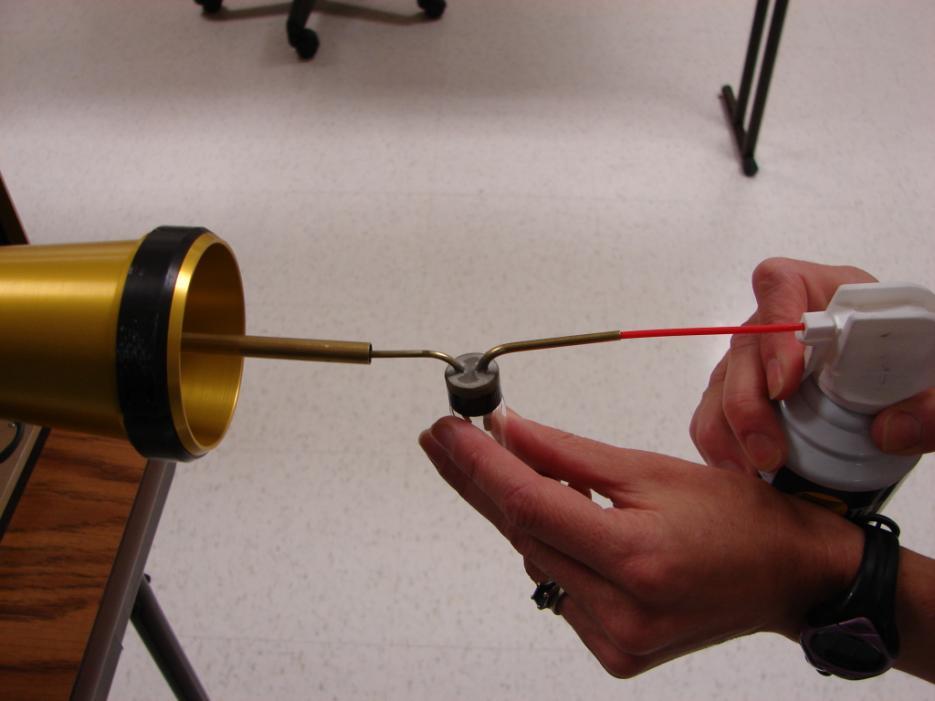 Figure 29: Blowing Glass Beads through the Calibration Device 9.) Keep pressing the duster as necessary, checking the data system display to see if the instrument is detecting the glass beads.