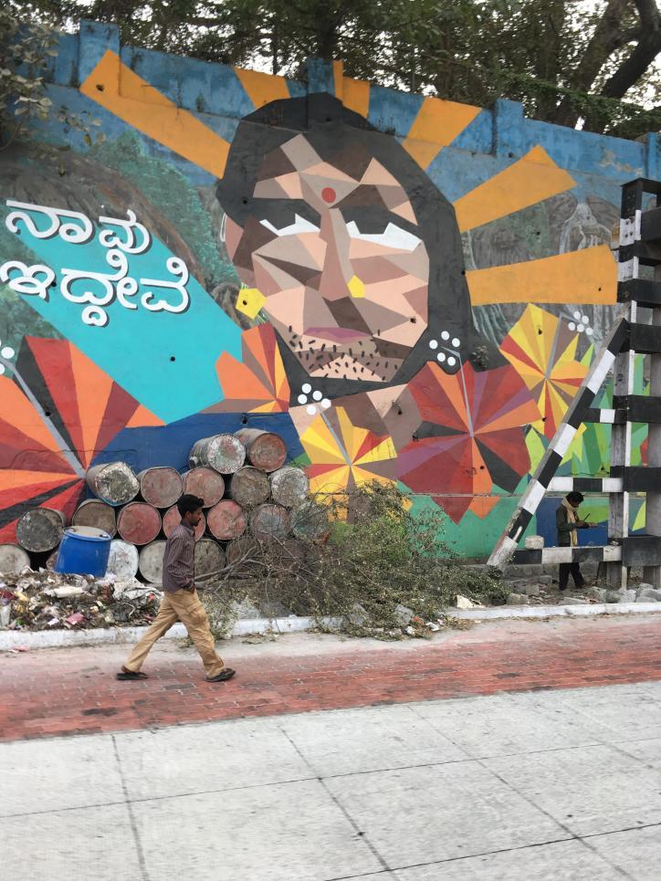 GRAFFITO #2 A colourful graffito of a face, with the text in kannada Navu idhivi, which translates to We exist in English, located at Navadhuri underpass, Bengaluru.