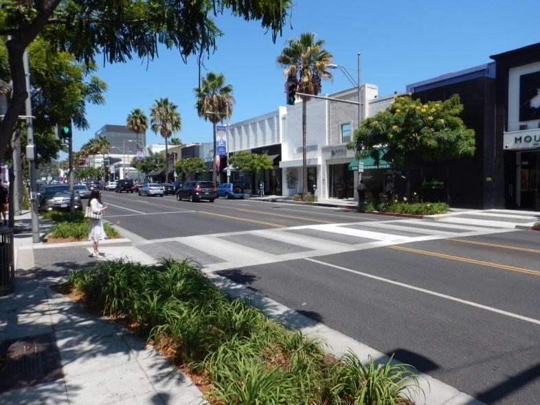 A mid block, signalized pedestrian crossing will allow pedestrians to easily shop both sides of the street.