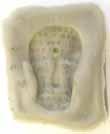 Figure 11: Imprint of Mask, a self-portrait carved from a potato. Grey candle wax with text.