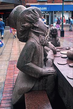 Assurance Society. It is made from granite and weighs 8 tons. The sculpture features the Mad Hatter, Sleepy Dormouse, March Hare and Alice herself seated at the head of the table.