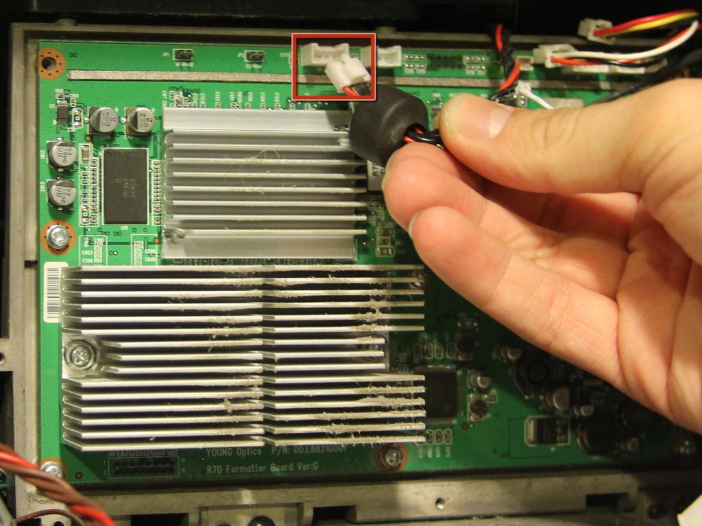 Gently hold each side of the metal frame and pull it straight back to reveal the board and heat sinks underneath.