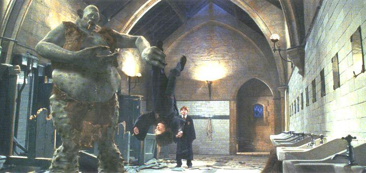 her, knocking the sinks off the wall as it goes. Within the next few moments Harry and Ron manage to confuse the troll so that it stops a few feet from Hermione.