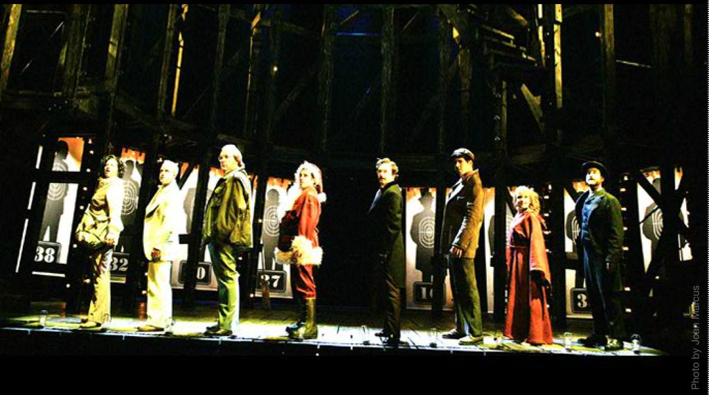 Robert Brill s design for the 2004 revival takes inspiration from the opening carnival barker sequence in the show and frames the musical s action within the decaying wooden support structure of a