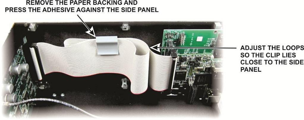 Slide the ribbon cable through the clip to adjust the folds so the clip lies near the side panel without being pulled away by the cable (see Figure 24).