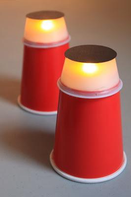 An easy design is this one below, created with red plastic cups, empty pudding cups, black paper, and battery-powered tea lights. Kids can even put little plastic people or animals inside.