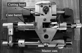48 INNOVATIONS OF HERZBERG PROFILER/SHAPER, THE SYMMETRICAL MACHINE Fig. 4) Cutting head, cane barrel and master cam. on the cam is precisely located to ride down the longitudinal center of the cam.
