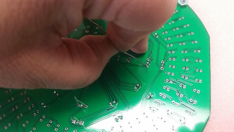 While soldering, hold the solder between your index finger and thumb, while pressing down on the board with your remaining fingers, as shown in Figure 6.