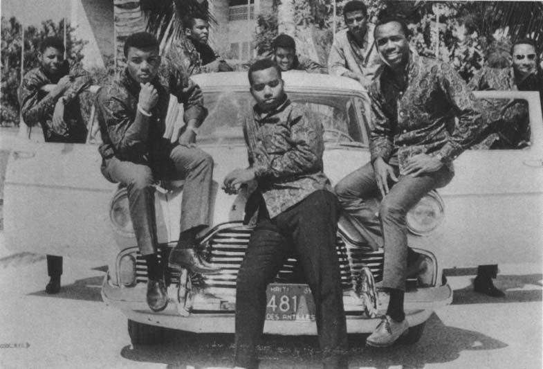 The mini-djaz Les Fantaisistes de Carrefour perched on a luxury automobile, wearing paisley shirts in front of a government building-celebrating the