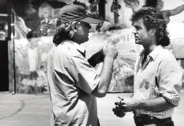mad men: Richard Donner with Mel Gibson in front of a mural in Venice Beach during the shooting of Lethal Weapon (1987).