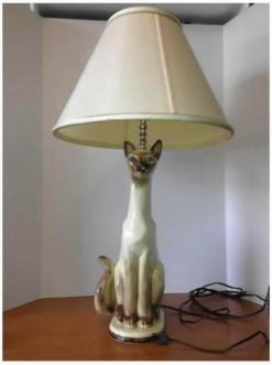 Obviously, the Siamese cat is physically separate from the lamp, as it could be easily removed while leaving both cat and lamp intact.