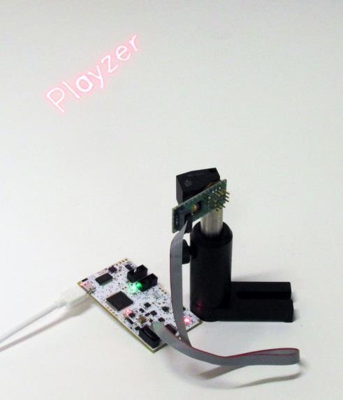 PLAYZER Evaluation Kit: EVK-01 EVK-01 or Playzer Evaluation Kit is a MEMS mirror technology demonstrator consisting of a MEMS mirror scan module with an eye safe 635nm laser (3-6mW) with 1-bit