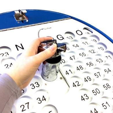 Call the number and place the ball in the appropriate hole on the tray and lightly press down.