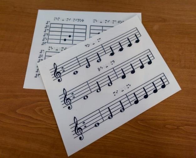 Figure 5: Sheets of tactile music with tactile score and Braille (swell-paper) Figure 6: Student exploring tactile sol key (swell-paper) The Thermoform will heat plastic film of paper to a point that