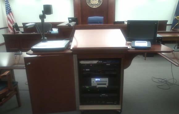 The Digital Presentation Podium At the heart of the electronic courtroom is the digital presentation podium, centrally located between the two counsel tables.