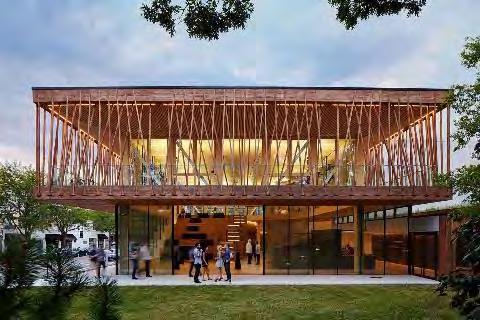 A second-floor gallery walk, providing views toward the downtown, lake, and nearby grove, is structured by timber Vierendeel trusses and a lighter wood lattice hung in tension from the primary