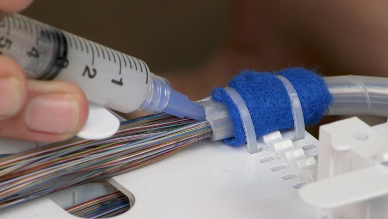flowing into the splice closure. The core tube or buffer tube plug is formed by injecting a one-inch (2.5 cm) long section of RTV silicone sealant into the tube.