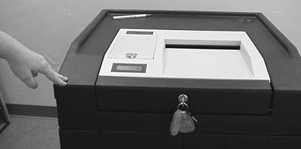 UNLOCK and open the compartment door on the left side of the ballot box using the black-rimmed key.