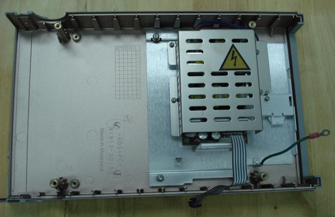 Use the T10 Torx screwdriver bit to remove the 4 screws attaching the PSU safety cover to the top clamshell. Lift and remove the safety cover. Remove the PSU cable guide (Figure 6-4).