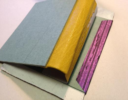 The book features two-part split boards, reinforced made endsheets, and a spring made of layers of card and paper.