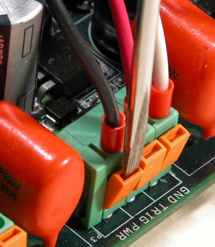 Using a small screwdriver, press gently on the orange tab in each terminal block to release the clamp and allow the wire to penetrate. Insert the wire in the respective hole.