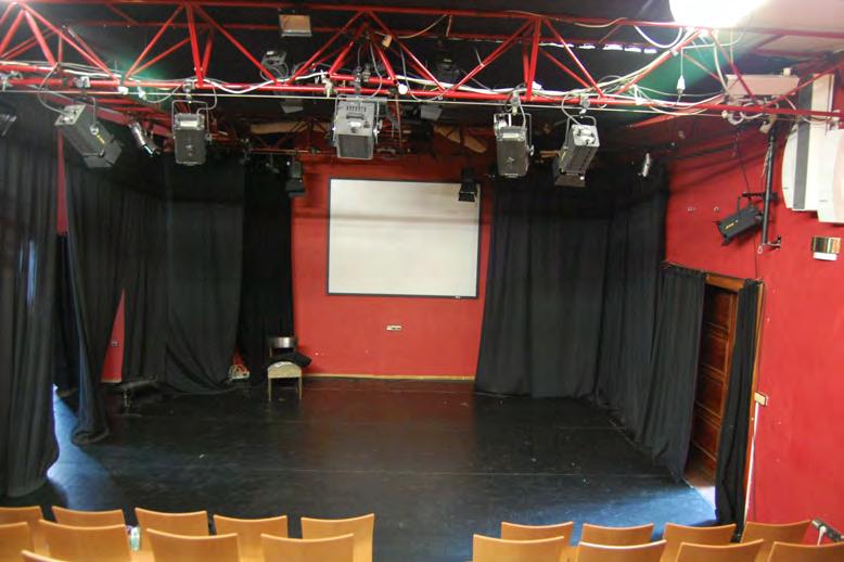 Venue with masking moved showing walls and fixed projection screen.