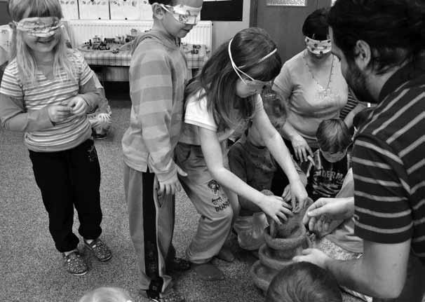 Izobraževalni programi Fotografija prikazuje povorko otrok in njihovo učiteljico s prevezami čez oči, ki so obrnjeni v desno smer.