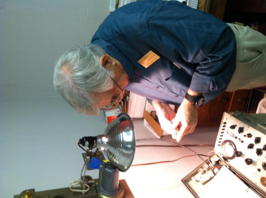 John Outland checking a vacuum tube in the tube room.