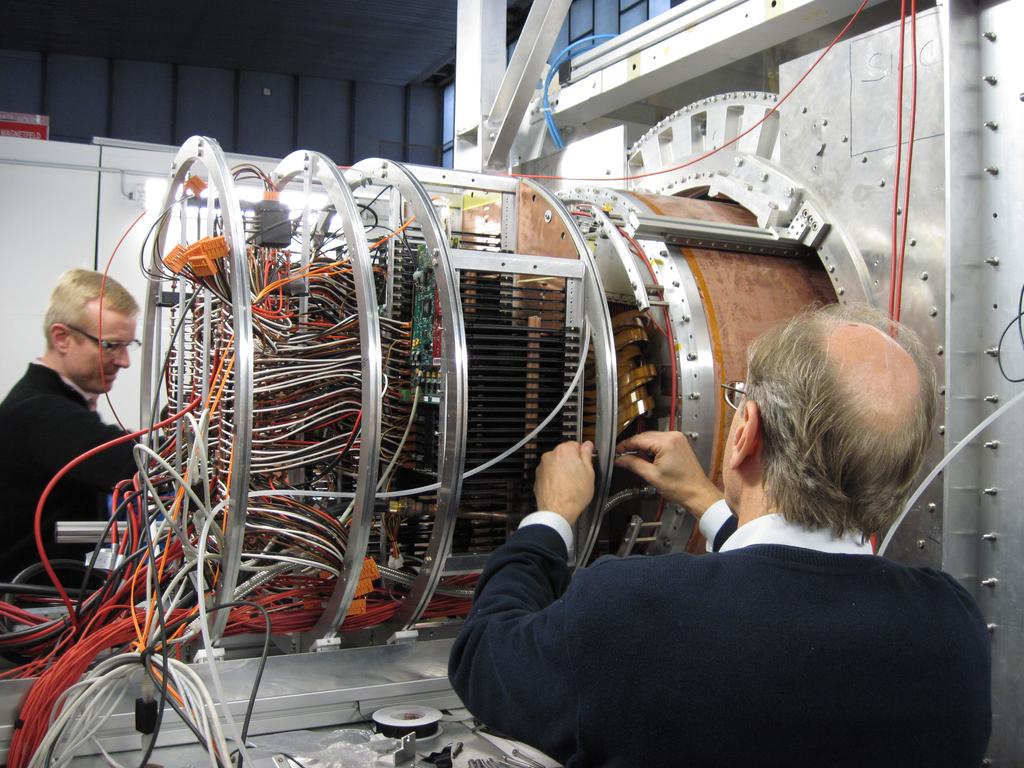 Figure 1: The front end electronics and its support structure attached to the TPC. Also seen are the optical cables for the data readout and the LV supply cables. Each FEC contains 18 channels i.e. 8 PCA16 chips and 8 ALTRO chips are mounted on each board.