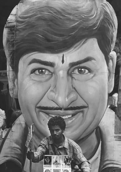 CINEMA 231 K. Nagaraj, an ardent fan of kidnapped superstar Rajkumar, stages a hunger strike in front of a huge cut-out of the actor in Bangalore, 9 August 2000.
