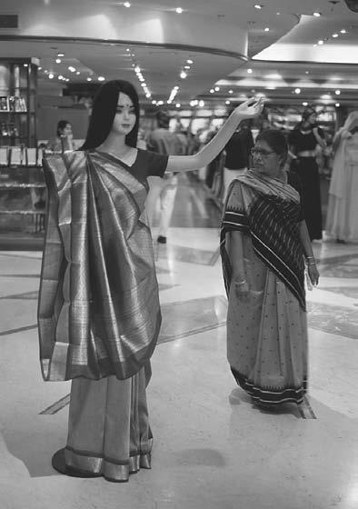 CONCLUSION 299 A woman stands next to a mannequin in a shopping center. Bangalore, 2001. (David H.