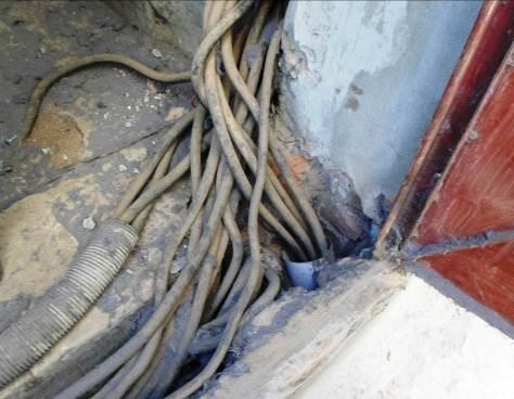 Finding #: E- 5 CABLE & CABLE SUPPORTS Service cables terminating from wall is not supported. Cables must be protected and supported and installed through safe and prescribed routes.