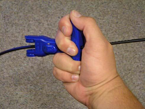 2. Place the Speed Splitter Tool on the cable at the point where the sheath enters the building. Clamp the tool over the OSP sheath and squeeze handles together as shown in Figure 18.