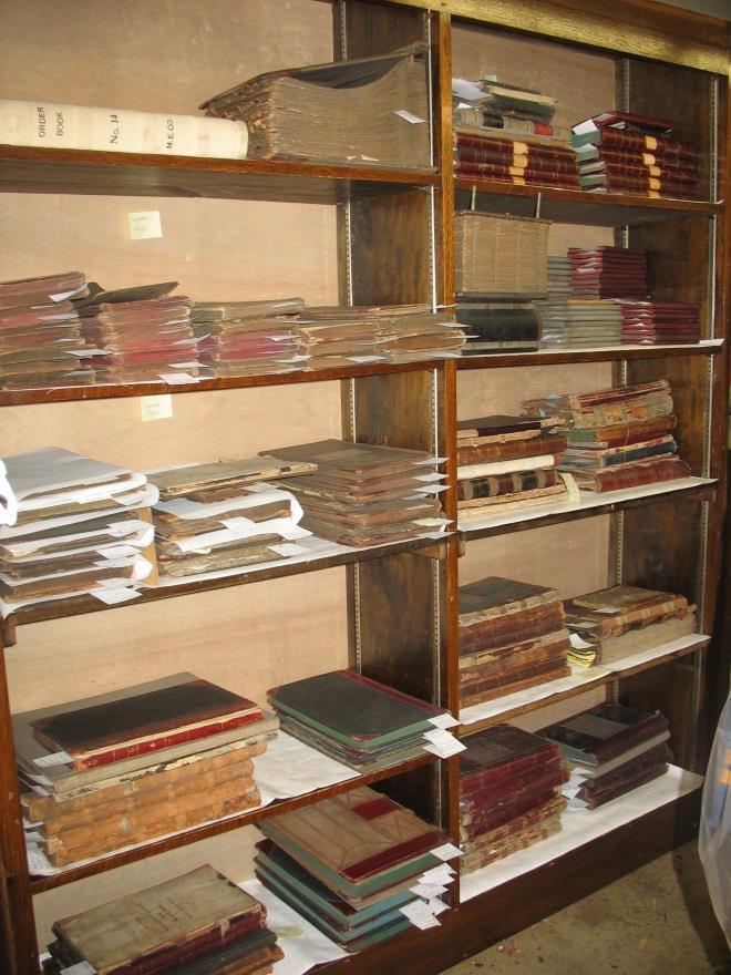 Ledgers: Ledger collection brought together and stored flat on shelves lined with