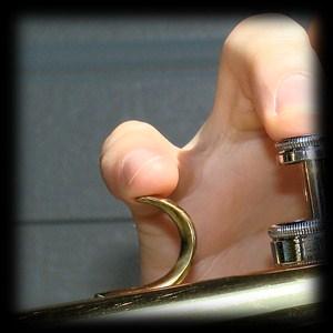 The weight of the trumpet is supported by the left hand.