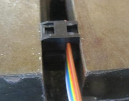 Squeeze the connector in a vice to push the top piece down on the cable and force it into the IDC pins.