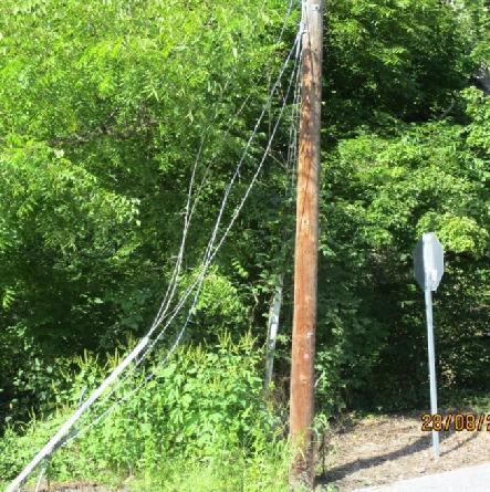 An old utility pole has been cut with Verizon s terminal still attached to it. The old pole does not appear secured to the new pole. It is left dangling causing a hazard to the public.