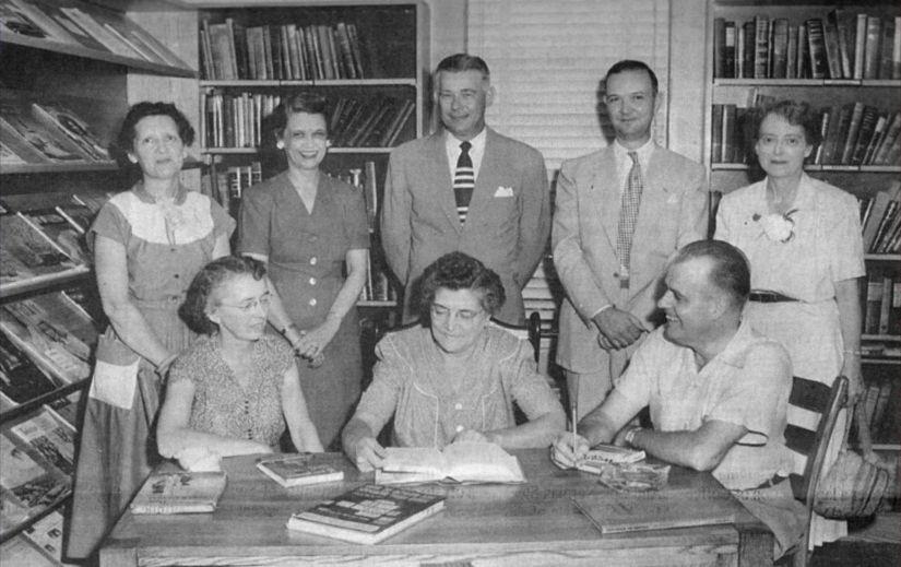 The back of this old photograph of the library lists those pictured as: seated, from left, Clara Starnes, librarian; Mrs. J. T. Moore Sr.