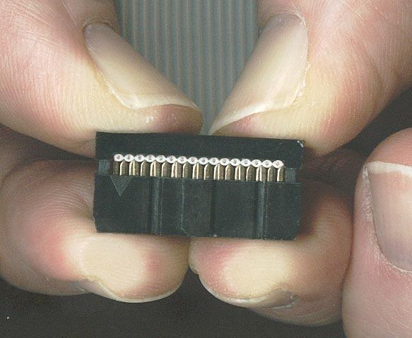 The upper portion has channels that fit over the individual conductors in the ribbon to hold them precisely in position as the connector is assembled.