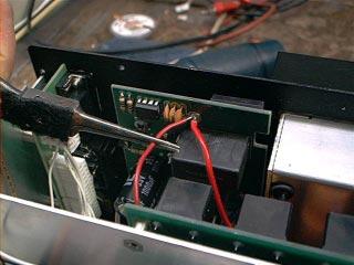 2d: Carefully position the tuner mounting bracket to align the mounting holes with existing holes in the side panels of the radio. See figure 4.